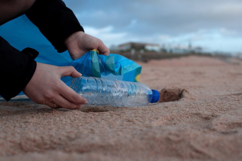 person holding clear plastic bottle